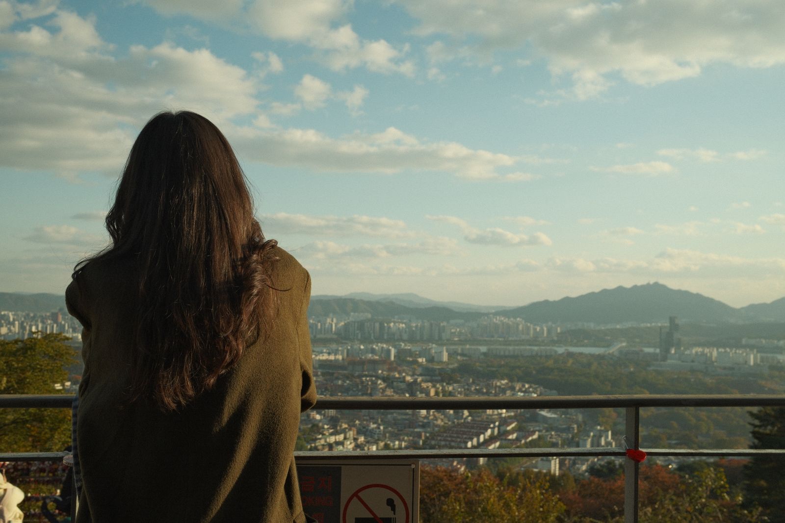 旅先の街を見下ろす後ろ姿の女性